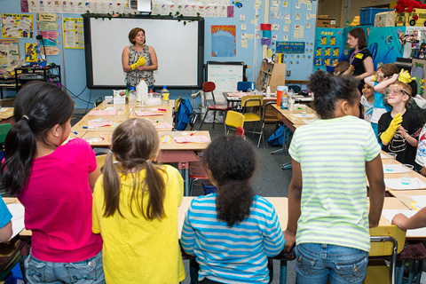 Volunteer standing in front of children in classroom