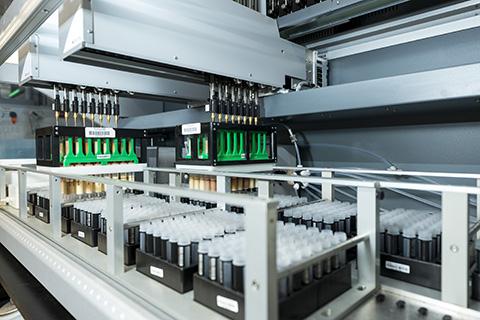 A scientific machine holding racks of vials