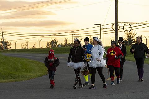 Photo of costumed employees rounding a bend in the road during the Halloween 5k
