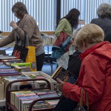 Women browsing books at the 2018 book and media swap.