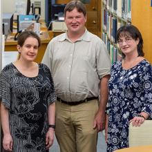 Three members of the Scientific Library staff are pictured inside the library.