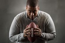 Studio portrait of James Cherry with a football.