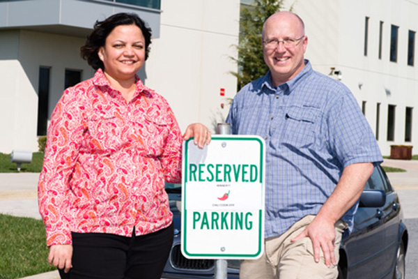 Sucheta Godbole, first place winner at the first Advanced Technology Research Facility Chili Cookoff, stands with John Stroka, event organizer, near the reserved parking space she was awarded for two weeks.