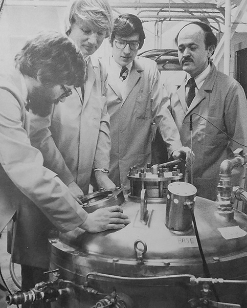Fermentation program staff examine one of the fermenters, c.1981. The second figure from the left is Richard White, Ph.D., the program director who succeeded Langlykke. (FCRC 1981 Annual Report)