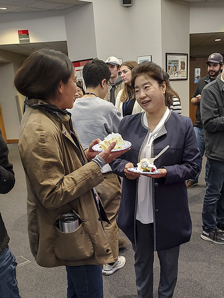 Hye Kyung Chung-Derse, Ph.D., (right) networks with an NCI Frederick employee after the lecture.