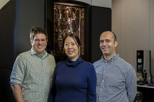 NCEF staff standing in front of the Titan Krios in Gaithersburg. From left: Thomas Edwards, Ph.D., microscopist; Helen Wang, scientific project manager; and Ulrich Baxa, Ph.D., senior microscopist.