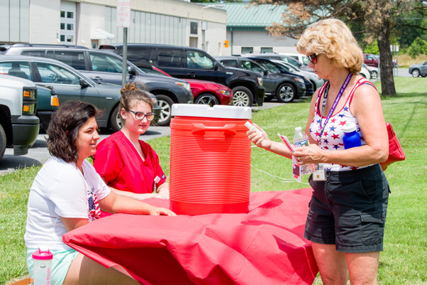Roberta Matthai stops for a water break and gets her pamphlet signed by OHS interns Emily Burnett and Kylie Tomlin. After gathering all three signatures, she was eligible to enter the raffle.