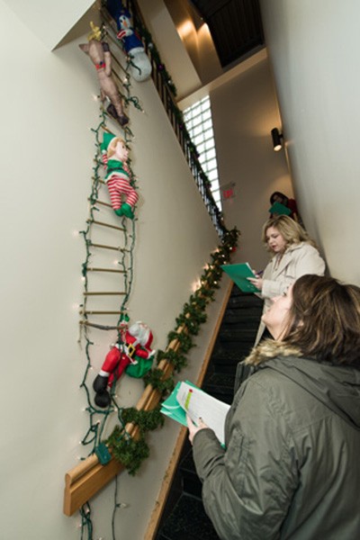 Judges Lisa Hill (background) and Lorie Maith-Sanders, from the Army Garrison, Army Community Service, evaluate decorations in Building 310.