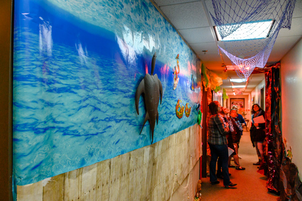 Building 310’s beach scene covers a wall (foreground), while employees stand in the glow of the construction-paper volcano (background)