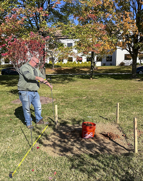 Dwayne Atherton, of FME, prepares the site for the sweetgum and the fence.