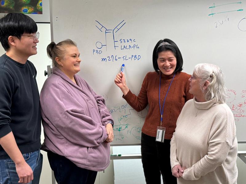 Feng is explaining some of the key mutations introduced into the m276-SL-PBD ADC to three other key people involved in the study. From left to right: Jaewon Lee, Mary Beth Hilton; Yang Feng; and Karen Morris. Photo credit: Brad St. Croix
