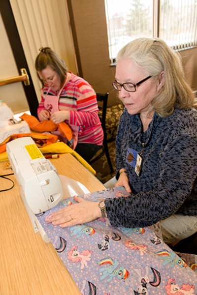 Annie Rogers (right) and Melissa Porter, Office of Scientific Operations, NCI at Frederick, sew the assembled fabric into finished pillowcases.