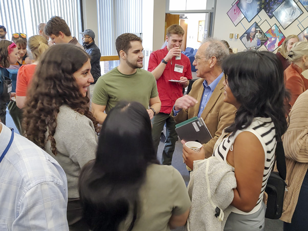 Friends and colleagues gather to chat and share stories about Rein during a meeting break. (Photo by Samuel Lopez)