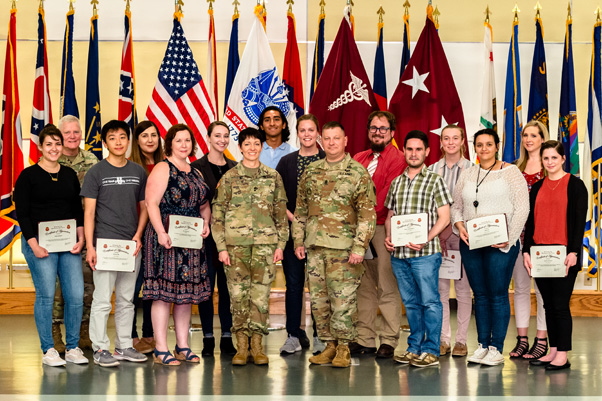 Lt. Col. Jaime Anderson, USAMRMC Strategic Partnership Office, (back row, second from left); Katherine Ramsburg, USAMRMC contractor, (back row, far right); and Command Sgt. Maj. Timothy Sprunger, USAMRMC and Fort Detrick, (center-left) joined Maj. Gen. Holcomb (front row, center-left) in congratulating the award recipients.