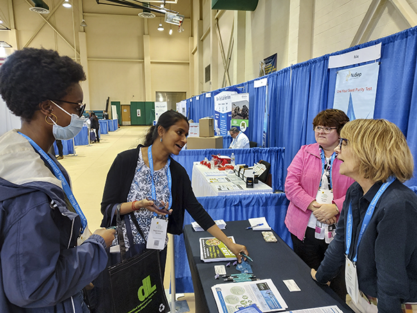 FNL’s Mary Ellen Hackett (right) and Pamela Nobel (center-right) speak with attendees at the vendor expo.