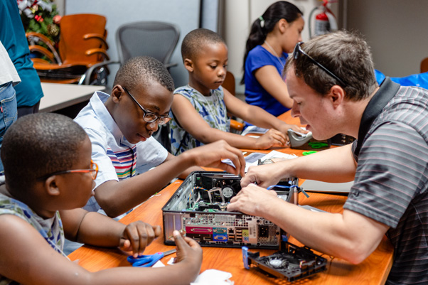 George French, of Data Management Services, Inc., shows children how to disassemble and reassemble a computer at the “What’s Inside a Computer?” program.