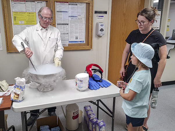 Walter Hubert, Ph.D., Frederick Office of Scientific Operations, “at work” (left): “The delectable cryogenic experiment is always great fun for children, young and old—rain or shine; of course, the lines are longer the warmer it is outside. And, yes, the makers enjoy mixing up flavors with non-intuitive colors. We overheard a youngster say, it ‘smells like toothpaste’ but had the looks of cotton candy—what a smart assessment at that age for a mint-flavored delight in pink,” he said.