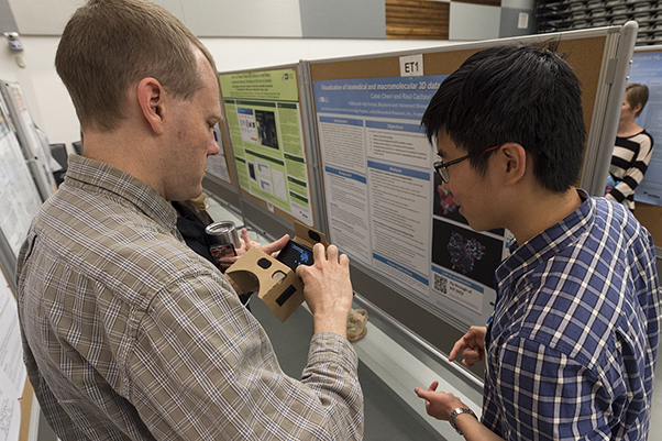 Caleb Chen (right), a WHK intern, explains his research during the scientific poster display.