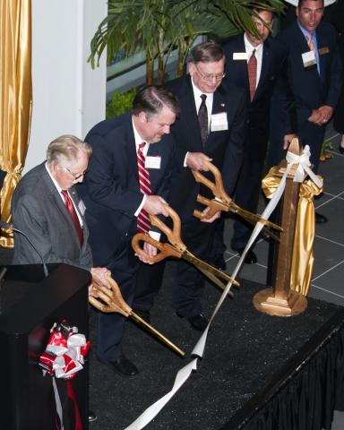 People cutting a ribbon.