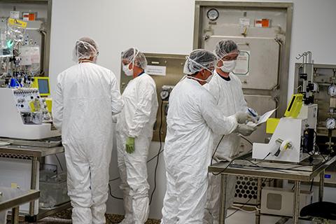 (Left) BDP staff monitoring a CliniMACs Prodigy system during CAR T cell cultivation; (Right) BDP staff scanning the bar code to load a tubing set onto the Prodigy system, preparing to start a CAR T cell production run.