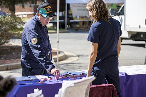 Photo of an OHS nurse interacting with a visitor at the farmers' market