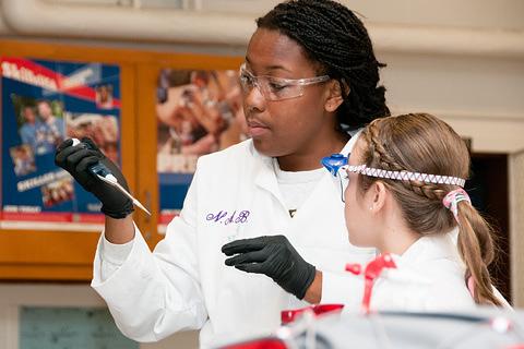 Woman demonstrating pipeting to student 