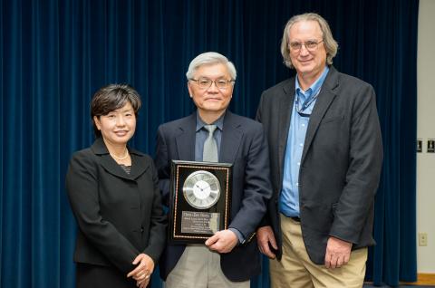 Three people with an award.