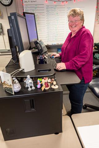 Woman standing at her workstation.