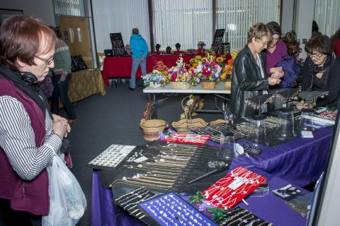 Employees browsing vendor tables at Holiday Market