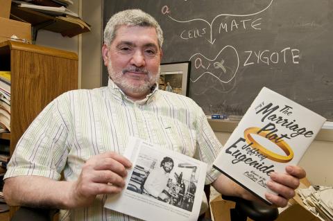 man holding book and aritcle.