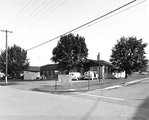 A building at the corner of an intersection, with the Frederick Cancer Research Center sign along the road in front of it