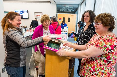 A woman checks out with her new books at the 2017 Book and Media Swap.