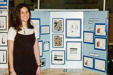 A student standing by a poster