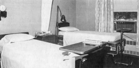 Black-and-white photo of a hospital room with two beds