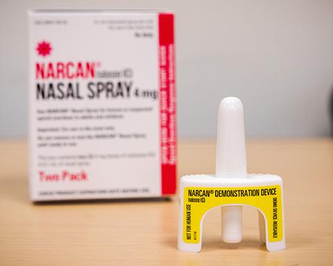 A nasal spray dose of NARCAN sits in front of its box