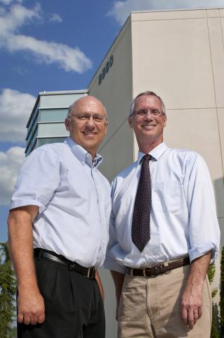 Two men standing in front of a building.