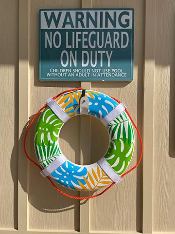 A life preserver and safety warning sign on a wall