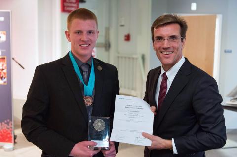 Two men holding an award.