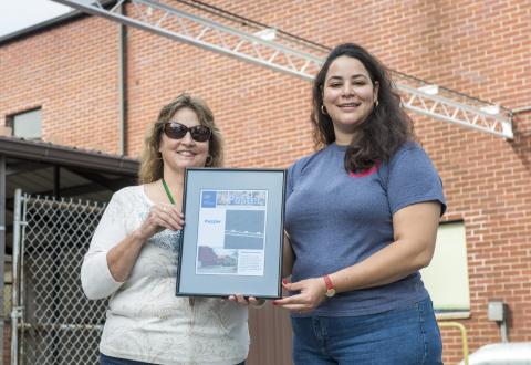 Two women holding a picture