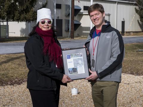 Woman and man holding a framed picture.