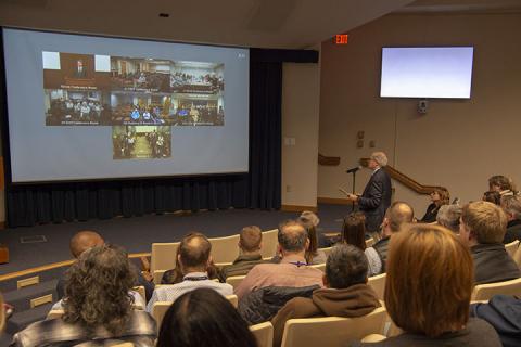 Employees watch the telecast in the Building 549 auditorium.