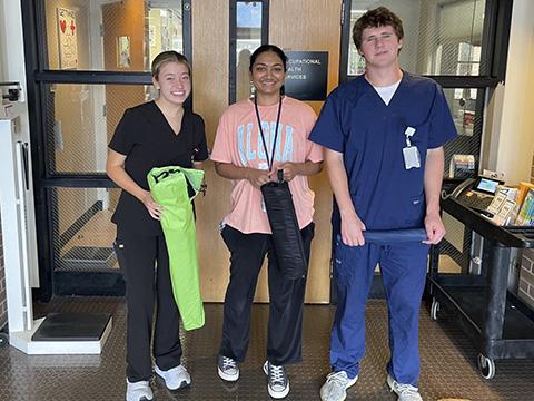 Three people standing and smiling for the camera