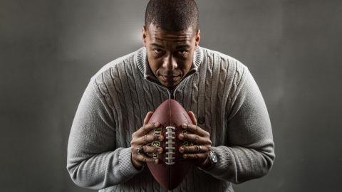 Studio portrait of James Cherry with a football.