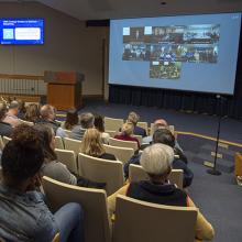 Employees watch the telecast in the Building 549 auditorium.