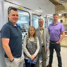 Four scientists standing in front of the NCI-60 robotic apparatus.