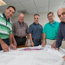 Group of men viewing plans.