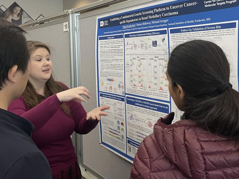 Postbac Olga Drozdovitch, winner of one of the oral presentation sessions, explains her research to Postbac Poster Day attendees.