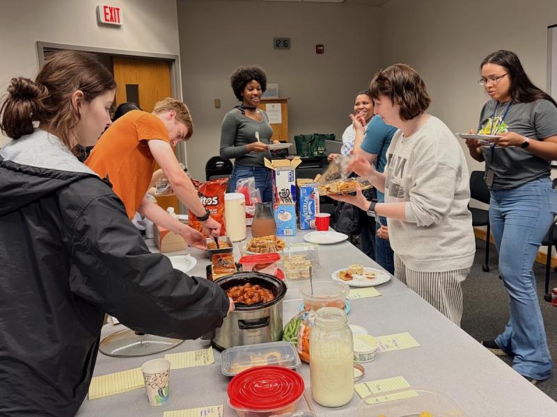 NCI Frederick fellows convene around the potluck spread to share food and conversation. (Image credit: Karolina Wilk)