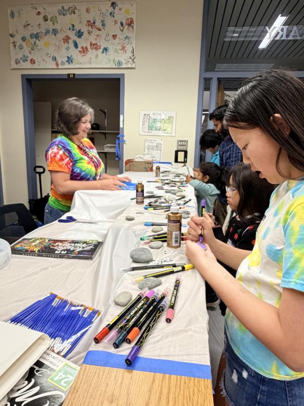 Kids queue up to decorate rocks as a volunteer looks on in the main activity hub in the old Scientific Library space, where drop-in activity stations were available this year. Image credit: Karolina Wilk