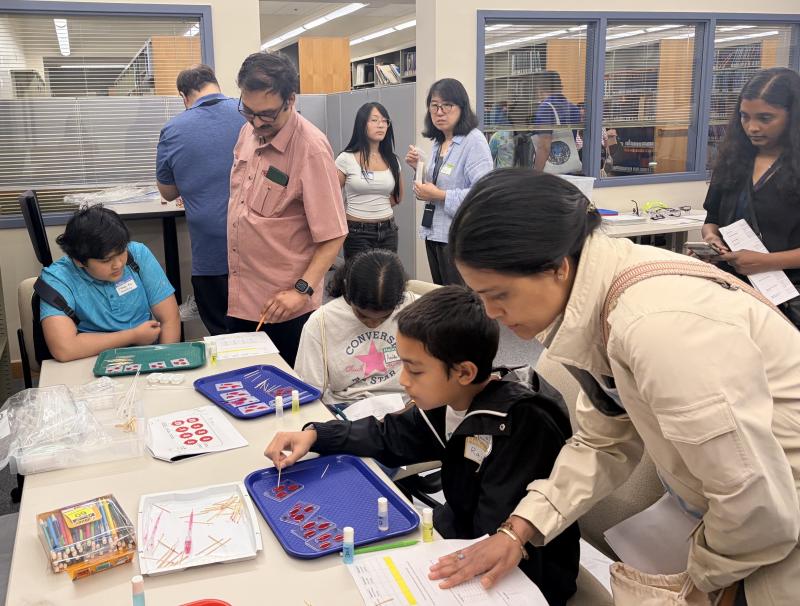 Kids and parents work on a simulated blood-typing activity as others wait their turn. Image credit: Karolina Wilk